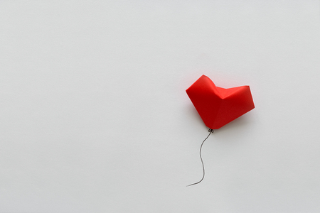 Valentines day card. Red paper heart shape balloons on thread. Origami and minimalist conceptの写真素材