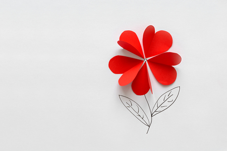 Valentines day card. Red paper heart shape flower on white paper background. Paper cut style and minimalist conceptの写真素材