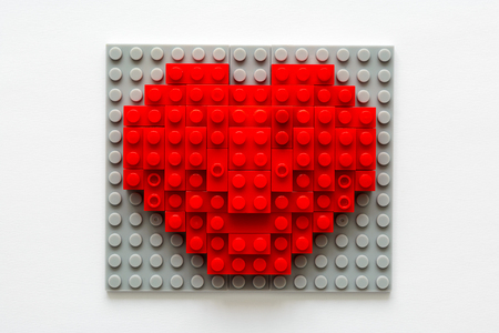 Red heart made from building blocks on gray background. Valentines day celebration and minimalist concept.の写真素材