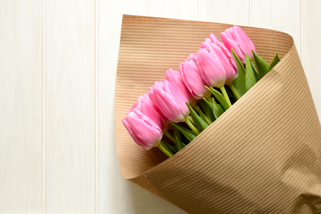 Bouquet of beautiful pink tulips on white wooden background. Top view. Copy spaceの写真素材