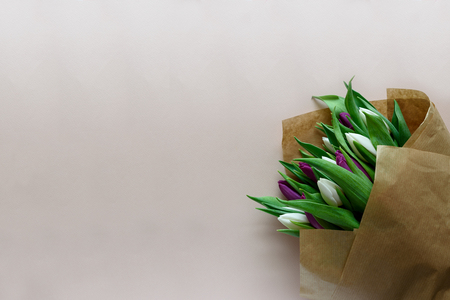 Bouquet of white and purple tulips on pink background. Top view. Flat lay. Copy space. Valentines day, mothers day, birthday, wedding celebration concept.の写真素材