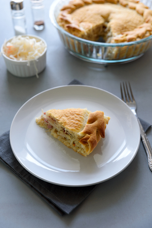 Slice of homemade sauerkraut pie on gray wooden table. Cabbage cake tradition russian foodの写真素材