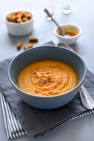 Bowl of red lentil soup on gray wooden background. Vegetarian food conceptの写真素材