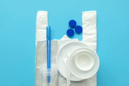 Plastic packages on blue background. Copy space. Top view. Eco and save earth concept.の写真素材