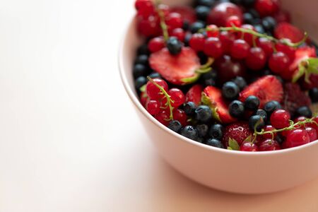 Porridge bowl oatmeal with berries on pink backgraund. Soft focus. Healthy eating concept. Front viewの写真素材