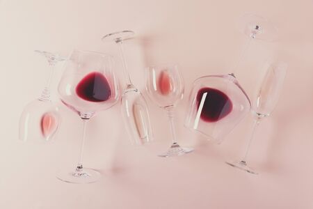 Assorted wineglasses with red, rose and white wine lying on pink background. Wine degustation...