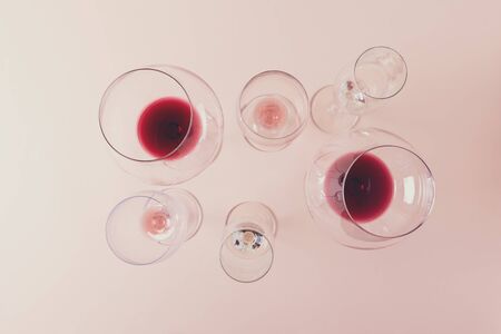Assorted wineglasses with red, rose and white wine stay on pink background. Wine degustation concept. Flat lay. Top view. Copy space. Tonedの写真素材