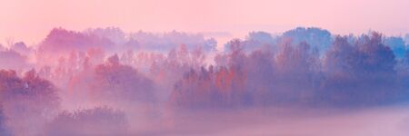 Banner 3:1. Close-up scenic foggy autumn landscape at sunrise. Aerial view on countryside. Colorful...