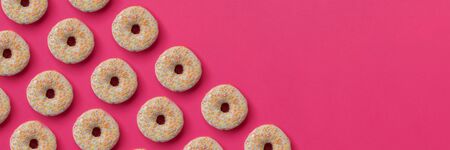 Banner 3:1. National Doughnut Day. Diagonal pattern from glazed donuts decorated colorful sprinkles...