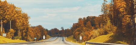 Traffic in high speed on a highway through rural landscape on sunset.の写真素材