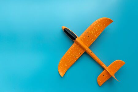 Airplane toy on blue background. top view. Flat lay. Travel or summer activity conceptの写真素材