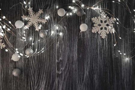 Christmas lights, balls and snowflakes over dark wooden background. Top viewの写真素材