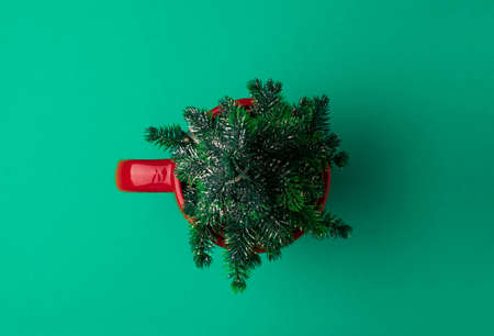 Coffee cup with Christmas tree on green background. New Year or Christmas celebration concept. Top viewの写真素材