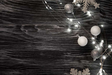 Christmas lights, balls and snowflakes over dark wooden background. Top viewの写真素材