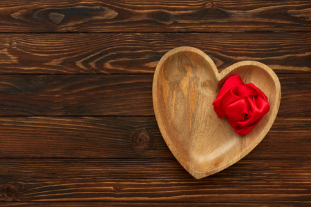 Heart plate on brown wooden background. Top view. Copy space. Valentines day celebration conceptの写真素材