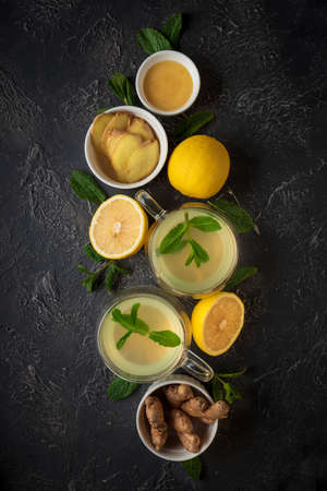 Ginger tea with mint, lemon and honey on concrete background. Top view