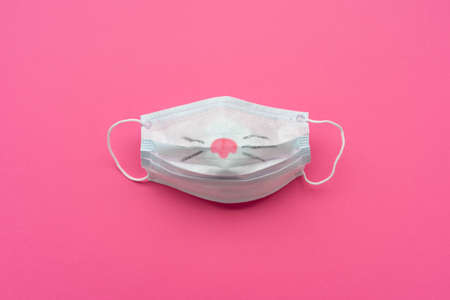 Protective mask with painted nose on pink background.の写真素材