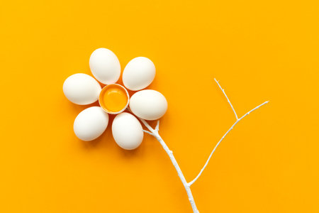 Flower make of white eggs and egg yolk into nest on yellow and gray background. Top view. Flat lay. Easter celebrationの写真素材