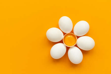 Flower make of white eggs and egg yolk into nest on yellow and gray background. Top view. Flat lay. Easter celebrationの写真素材