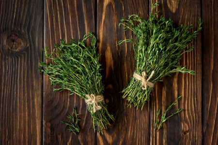 Fresh herb thyme on brown wooden background. Top viewの写真素材