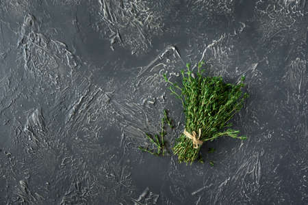 Fresh herb thyme on black kitchen table. Top view