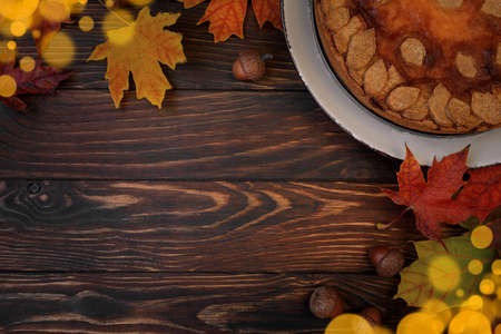 Autumn background with pumpkin cake, maple leaves, aples and acorns. Top view. Copy spaceの写真素材