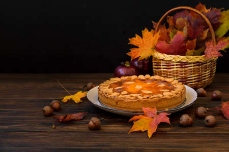 Autumn background with pumpkin cake, maple leaves, aples and acorns. Copy spaceの写真素材