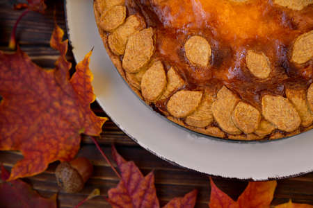 Autumn background with pumpkin cake, maple leaves and acorns. Top viewの写真素材