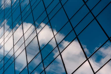 Glass building with cloudy blue sky reflaction. Urban backgroundの写真素材