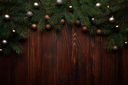 Christmas background with baubles and fir branches on dark wooden board. Top view. Copy space. Xmas decorationの写真素材