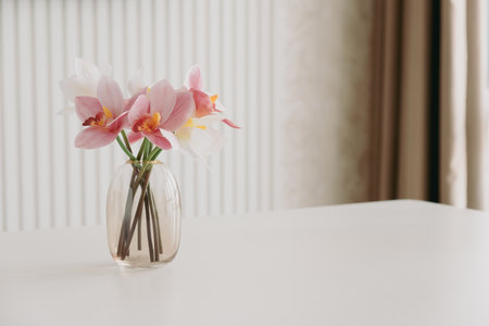 White and pink orchids in vase on white table. Copy spaceの写真素材