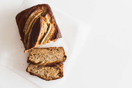 Sliced fresh homemade banana bread on white table. Top view