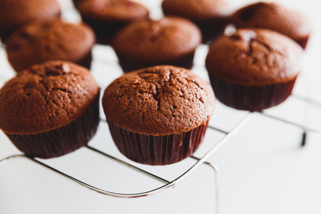 Homemade baked cherry muffins with fresh berries on white wooden tableの写真素材