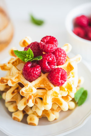Homemade baked Belgian ricotta waffles with fresh berries on white wooden tableの写真素材