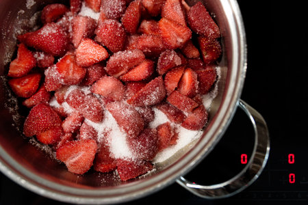 Making sweet strawberry jam in kitchen. Summer food concept. Top viewの写真素材