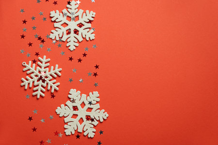 Red Christmas background with glitter snowflakes and star confetti. Christmas and Happy New Year celebration concept. Top viewの写真素材