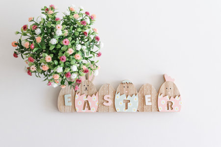 Easter decoration with easter eggs and flowers on white table. Top view