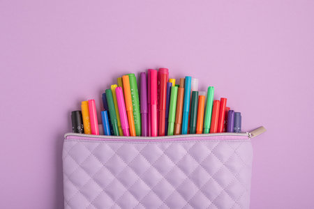 Pencil case with school supplies on purple g background. Top view. Copy spaceの写真素材