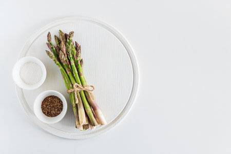 Fresh asparagus shoots with spices on white table. Top viewの写真素材