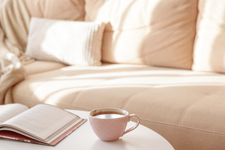 Cozy living room with a book and tea on a beige couch. Soft focusの写真素材