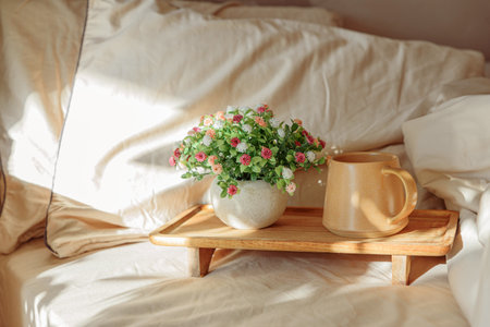 Breakfast in bed with coffee and a potted plant on a wooden tray.の写真素材
