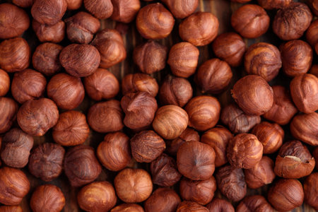 Close-up of roasted hazelnuts on a wooden surface. Top view