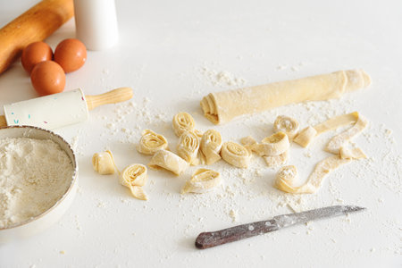 Ingredients and tools for making fresh homemade pasta on a floured surface.の写真素材
