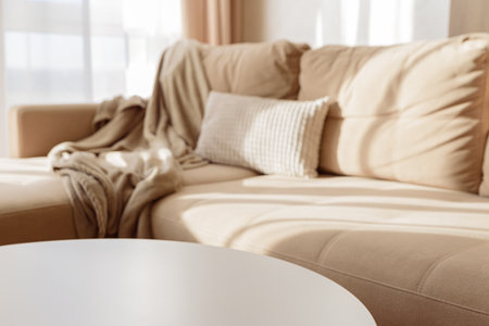Empty white coffee table in a cozy living room with a beige couch.の写真素材