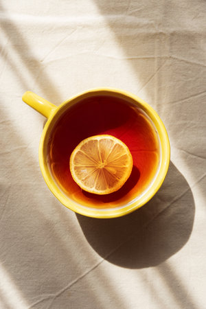 Flat Lay with Lemon Tea on Light Table under Sun Lightの写真素材