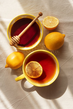 Flat Lay with Lemon Tea and Honey on Light Table under Sun Light