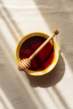 Honey with dipper on Light Table under Sun Lightの写真素材