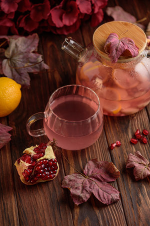 Autumn Beverage: Pomegranate Tea with Lemon and Ginger on Rustic Tableの写真素材
