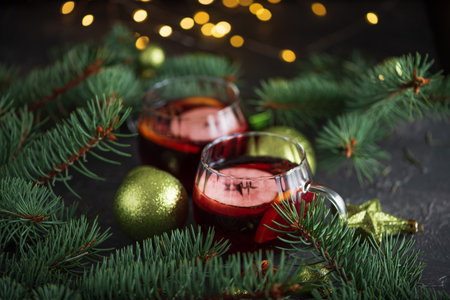 Two Glass Mugs of Mulled Wine with Christmas Decor and Fairy Lights