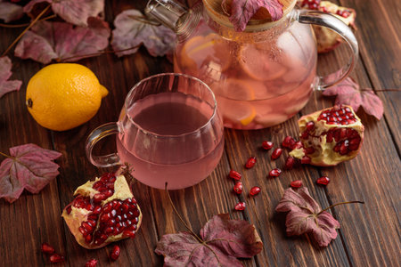 Autumn Beverage: Pomegranate Tea with Lemon and Ginger on Rustic Tableの写真素材
